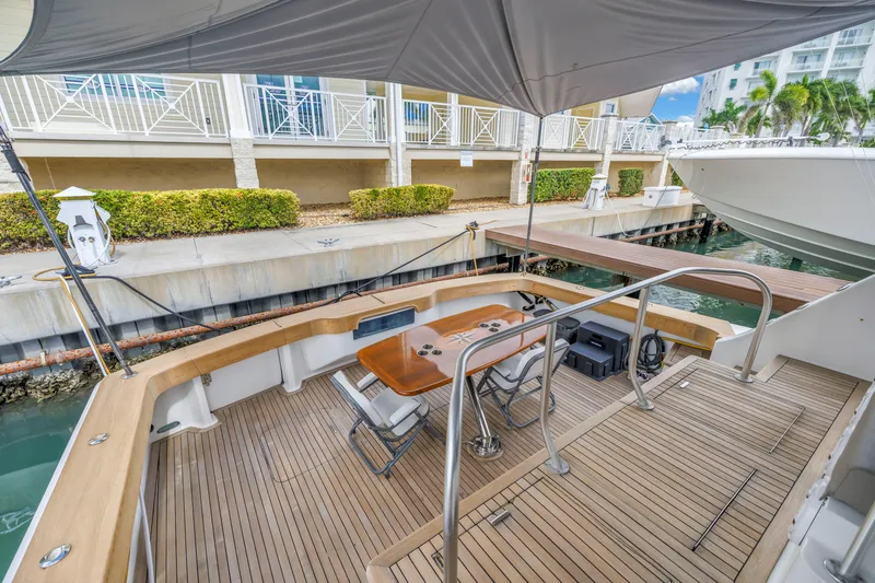 Slide: The Image of 1999 Viking 72 Enclosed Bridge yacht deck with seating and table, docked at marina. - 31