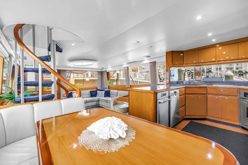 Slide: The Image of Luxurious interior of 1999 Viking 72 Enclosed Bridge yacht with modern kitchen and spiral staircase. - 33