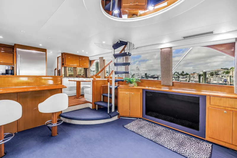 Slide: The Image of Luxurious interior of 1999 Viking 72 Enclosed Bridge yacht with modern furnishings and marina view. - 41