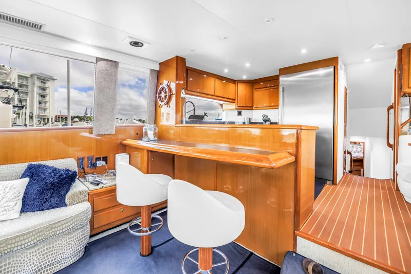 Slide: The Image of Luxurious interior of 1999 Viking 72 Enclosed Bridge yacht with modern kitchen and seating area. - 44