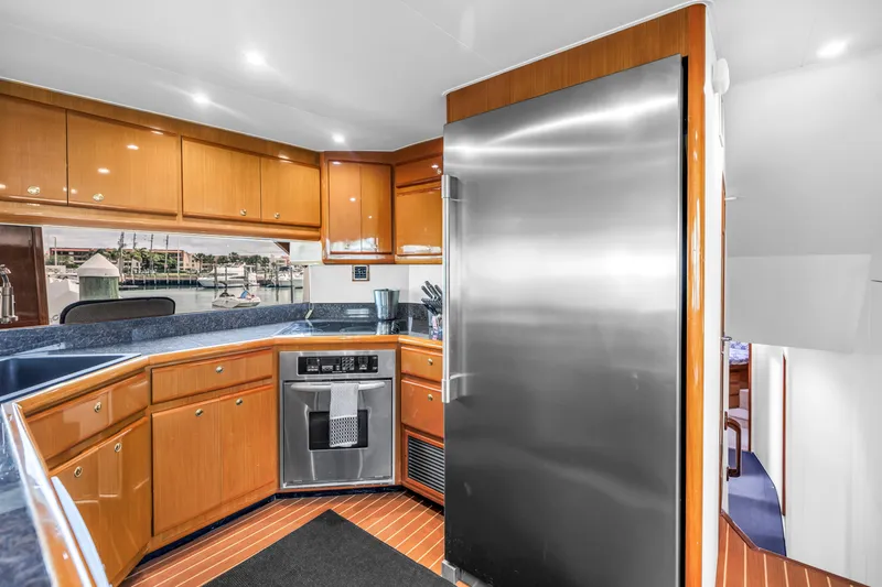 Slide: The Image of Luxurious kitchen interior of 1999 Viking 72 Enclosed Bridge yacht with modern appliances. - 47