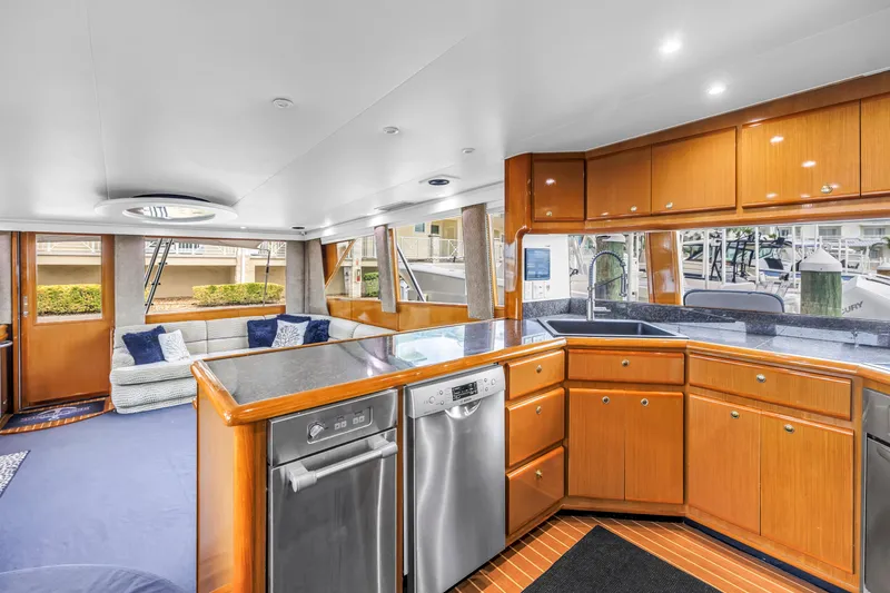 Slide: The Image of Luxurious interior of 1999 Viking 72 Enclosed Bridge yacht with modern kitchen and seating area. - 48