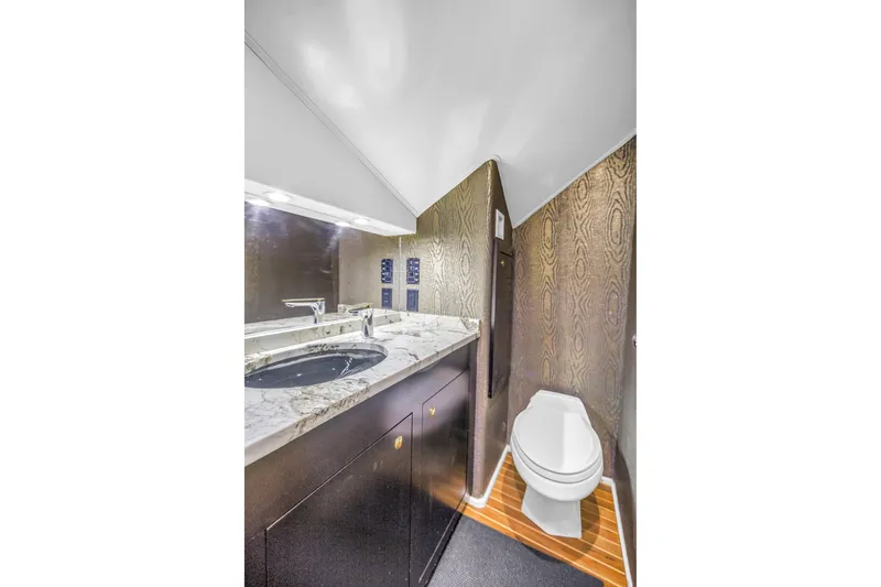 Slide: The Image of Luxurious bathroom in 1999 Viking 72 Enclosed Bridge yacht with marble countertop and modern fixtures. - 49