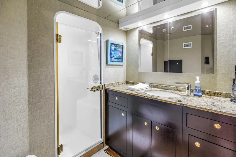 Slide: The Image of Luxurious bathroom in 1999 Viking 72 Enclosed Bridge yacht with granite countertop and modern fixtures. - 54