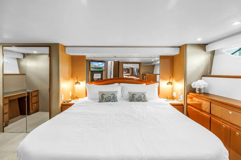 Slide: The Image of Luxurious bedroom interior of 1999 Viking 72 Enclosed Bridge yacht with elegant wood finishes. - 58