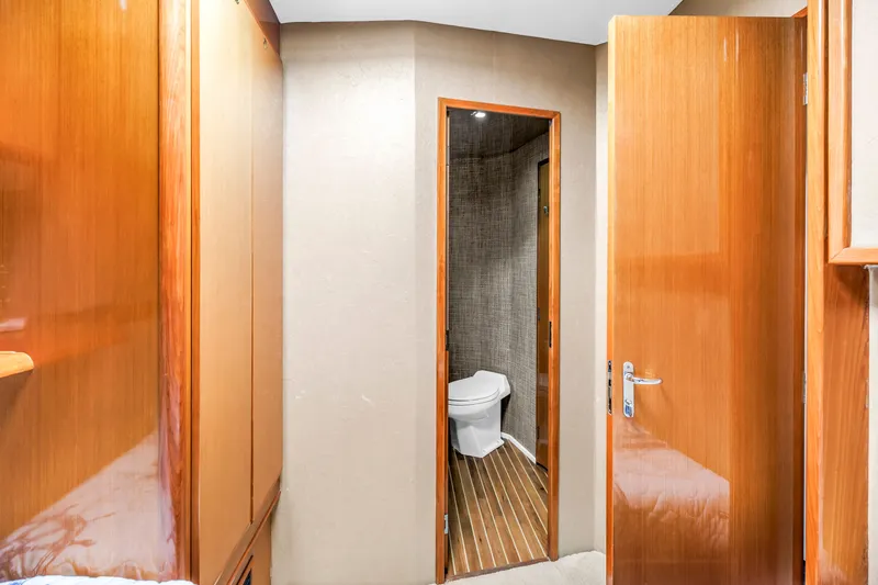 Slide: The Image of Interior of 1999 Viking 72 Enclosed Bridge yacht with wooden doors and bathroom. - 62