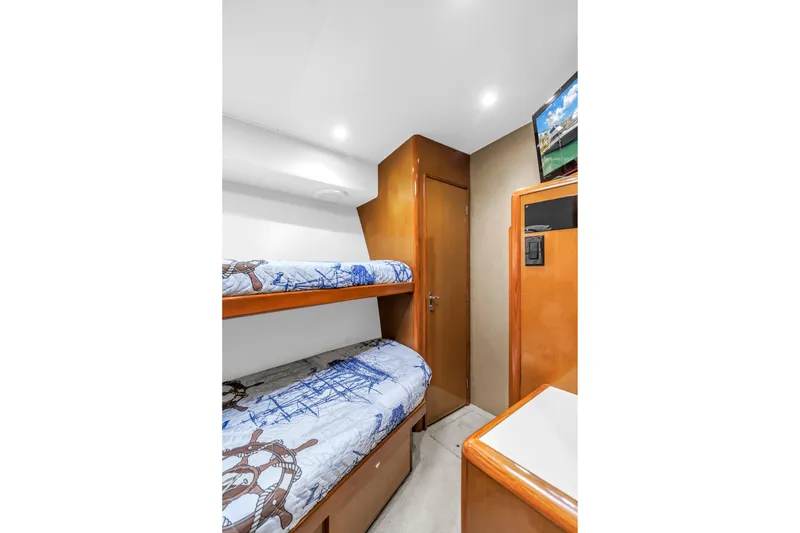 Slide: The Image of 1999 Viking 72 Enclosed Bridge cabin with bunk beds and nautical-themed decor. - 65
