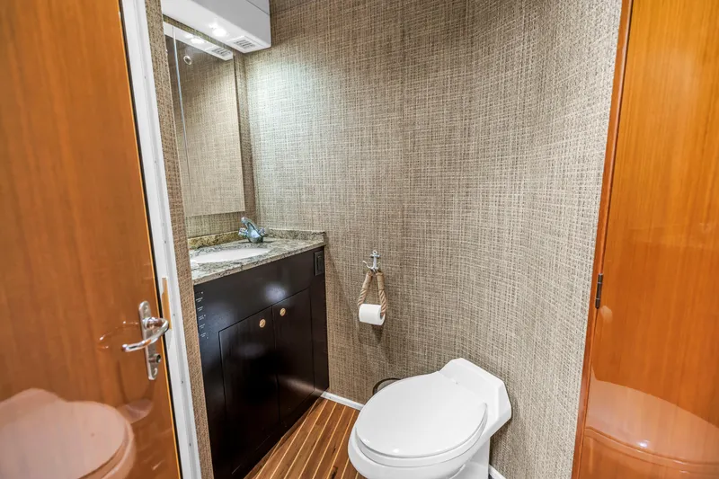 Slide: The Image of Luxurious bathroom in 1999 Viking 72 Enclosed Bridge yacht with modern fixtures and wood accents. - 67