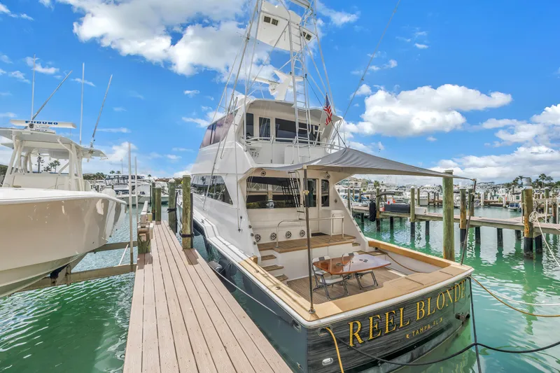 Slide: The Image of Luxury 1999 Viking 72 Enclosed Bridge yacht docked at marina under blue sky. - 7