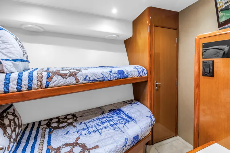 Slide: The Image of Bunk beds in 1999 Viking 72 Enclosed Bridge yacht cabin with nautical-themed bedding. - 72