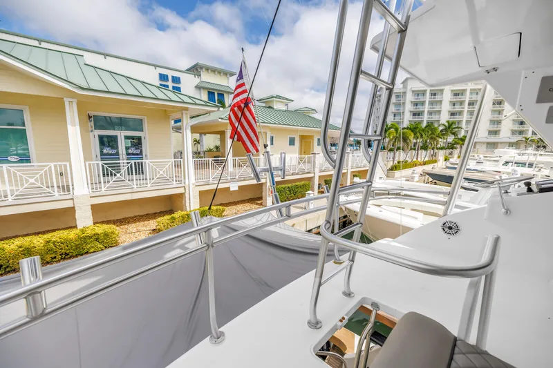 Slide: The Image of 1999 Viking 72 Enclosed Bridge yacht docked at marina with American flag. - 75
