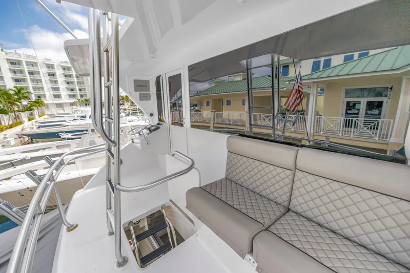 Slide: The Image of 1999 Viking 72 Enclosed Bridge yacht interior with seating and marina view. - 76