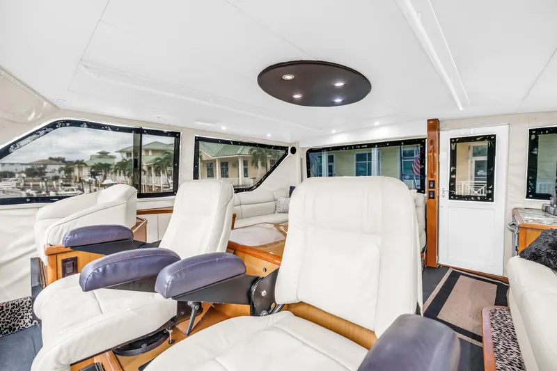 Slide: The Image of Luxurious interior of 1999 Viking 72 Enclosed Bridge yacht with plush seating and panoramic windows. - 78