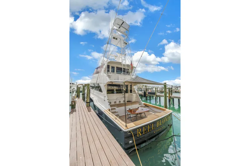 Slide: The Image of 1999 Viking 72 Enclosed Bridge yacht docked at marina under blue sky. - 8