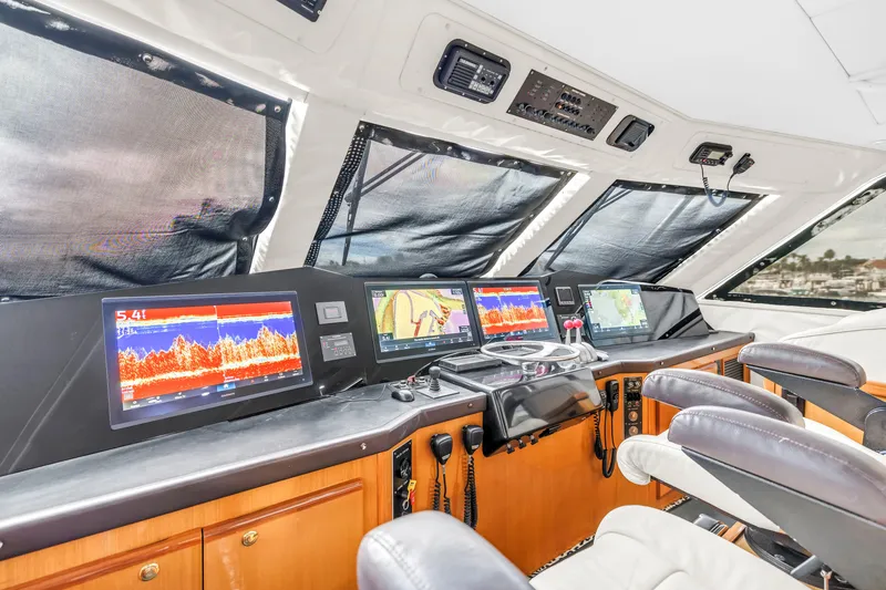 Slide: The Image of Bridge interior of 1999 Viking 72 Enclosed, featuring advanced navigation displays and controls. - 87