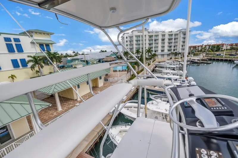 Slide: The Image of View from 1999 Viking 72 Enclosed Bridge yacht overlooking marina and waterfront buildings. - 94