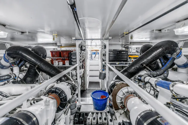 Slide: The Image of Engine room of 1999 Viking 72 Enclosed Bridge yacht, featuring complex machinery and equipment. - 98