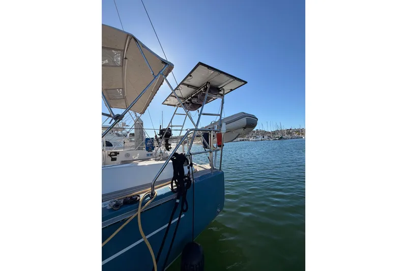 Slide: The Image of 2008 Hanse 540e yacht docked, featuring solar panels and a dinghy. - 12