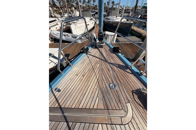 Slide: The Image of 2008 Hanse 540e yacht deck with wooden finish and metal railings in marina. - 18