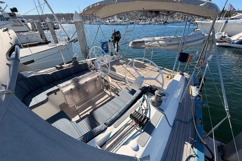 Slide: The Image of 2008 Hanse 540e sailboat cockpit with seating, steering wheel, and marina view. - 25