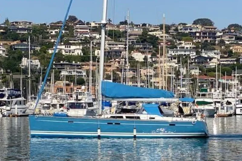 Slide: The Image of Blue 2008 Hanse 540e sailboat docked in a marina with hillside houses in the background. - 3
