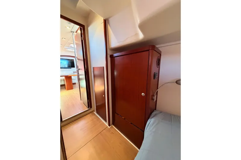 Slide: The Image of Interior of 2008 Hanse 540e yacht, featuring wooden cabinetry and cozy sleeping area. - 56
