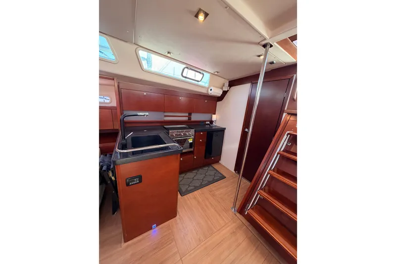 Slide: The Image of Interior of 2008 Hanse 540e yacht, featuring a modern kitchen with wood finishes. - 61