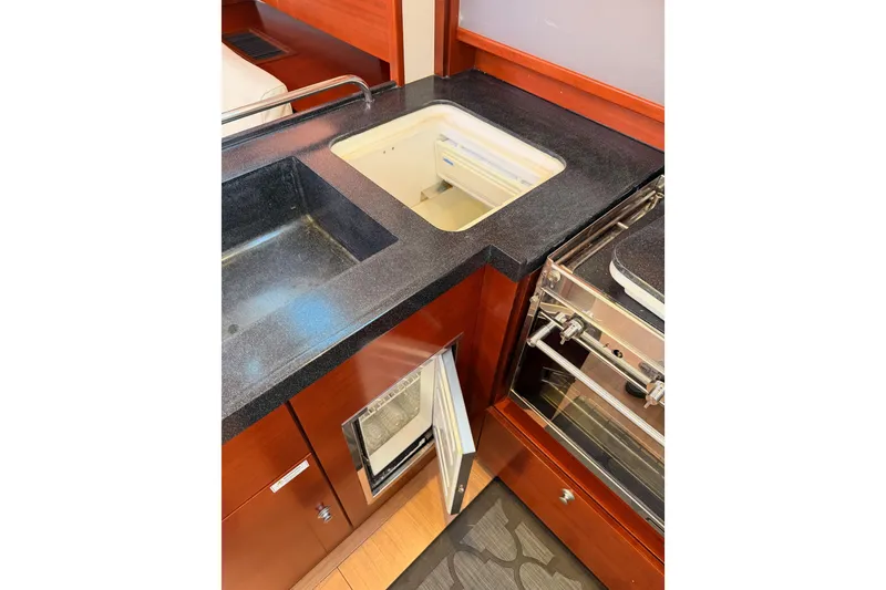 Slide: The Image of 2008 Hanse 540e yacht kitchen with sink, stove, and open fridge. - 72