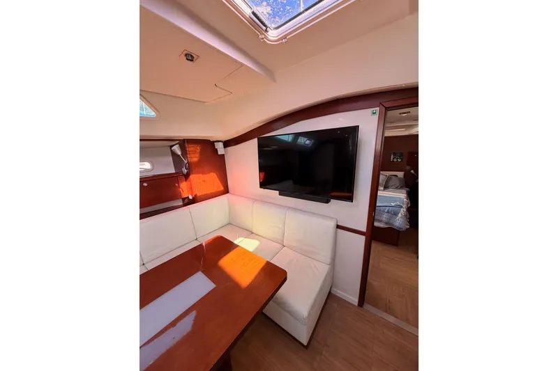 Slide: The Image of Interior of 2008 Hanse 540e yacht with white seating and wooden table. - 78