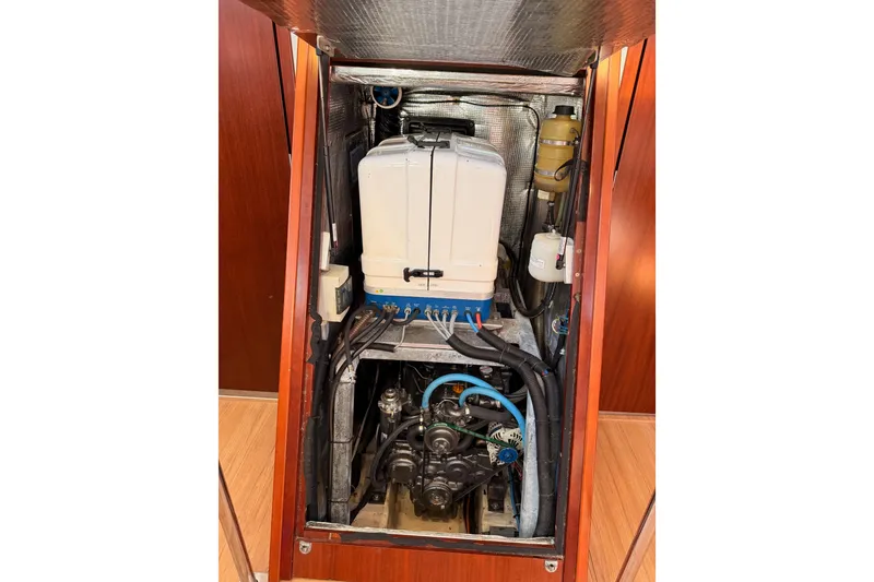 Slide: The Image of Engine compartment of a 2008 Hanse 540e sailboat, showcasing mechanical components and wiring. - 91