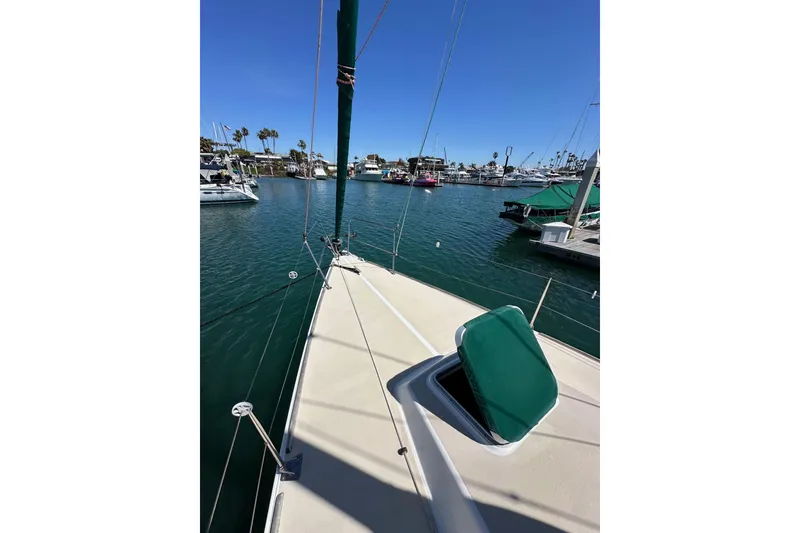 Slide: The Image of 1996 J Boats J/120 sailboat docked in a sunny marina with clear blue skies. - 13