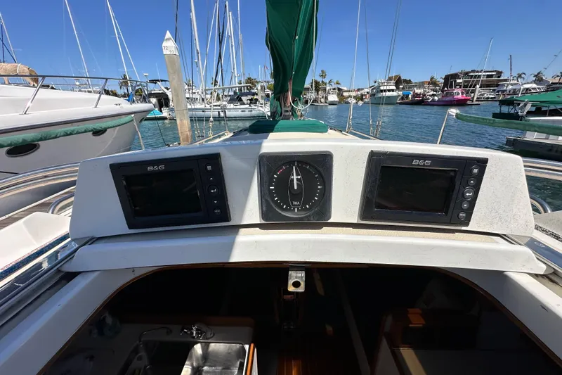 Slide: The Image of 1996 J Boats J/120 cockpit with navigation instruments, docked in a marina. - 34