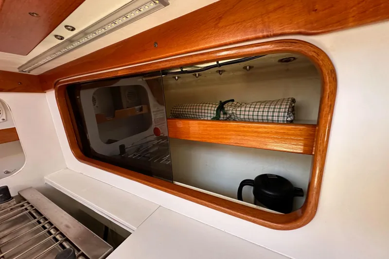Slide: The Image of Interior of 1996 J Boats J/120 sailboat with wooden shelves and kitchen area. - 42