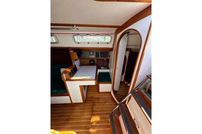 Slide: The Image of 1996 J Boats J/120 interior with wood finish, compact dining area, and natural light. - 43