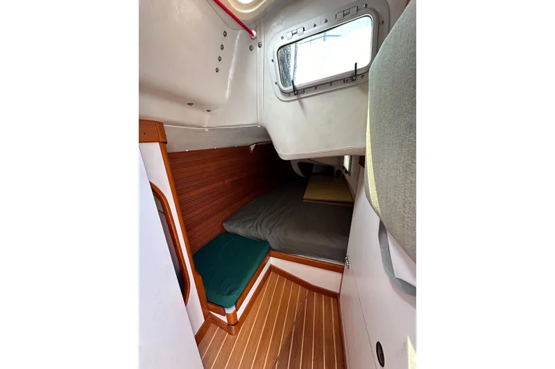 Slide: The Image of Interior cabin of 1996 J Boats J/120 sailboat with wooden flooring and cozy sleeping area. - 45