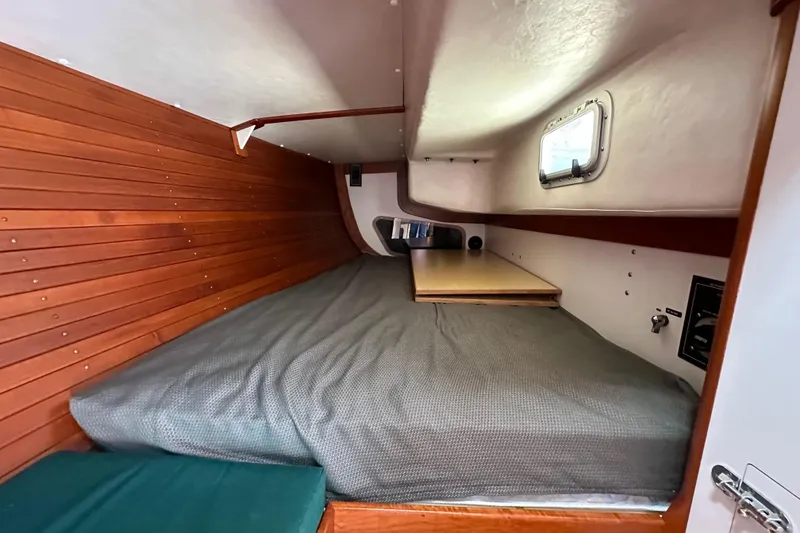 Slide: The Image of 1996 J Boats J/120 cabin interior with wooden paneling and cozy sleeping area. - 46