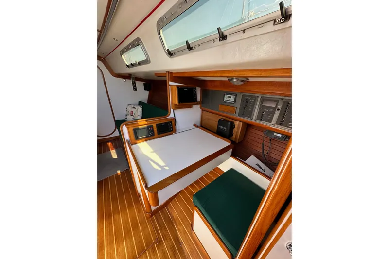 Slide: The Image of 1996 J Boats J/120 interior with navigation station, wood finish, and green seating. - 49