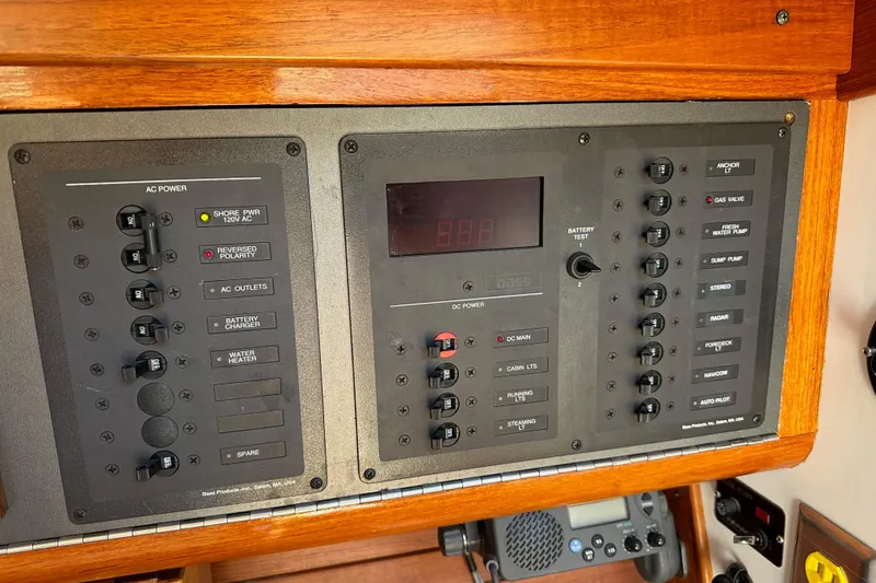 Slide: The Image of Electrical control panel on a 1996 J Boats J/120 sailboat, featuring AC and DC power switches. - 53