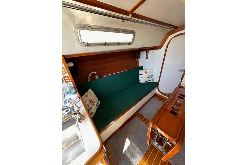 Slide: The Image of Interior of 1996 J Boats J/120 sailboat with green cushioned seating and wooden accents. - 58