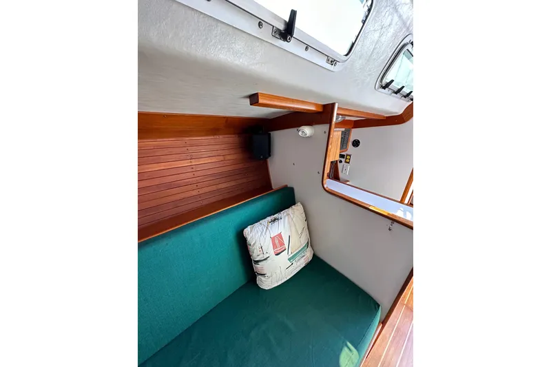 Slide: The Image of Interior of 1996 J Boats J/120 sailboat with green cushion and nautical-themed pillow. - 61