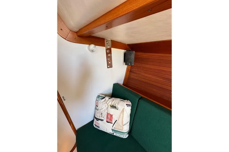 Slide: The Image of Interior of 1996 J Boats J/120 with green cushion and nautical-themed pillow. - 62