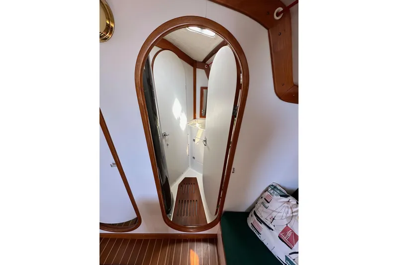 Slide: The Image of Interior of 1996 J Boats J/120 sailboat, featuring wooden trim and compact bathroom. - 63