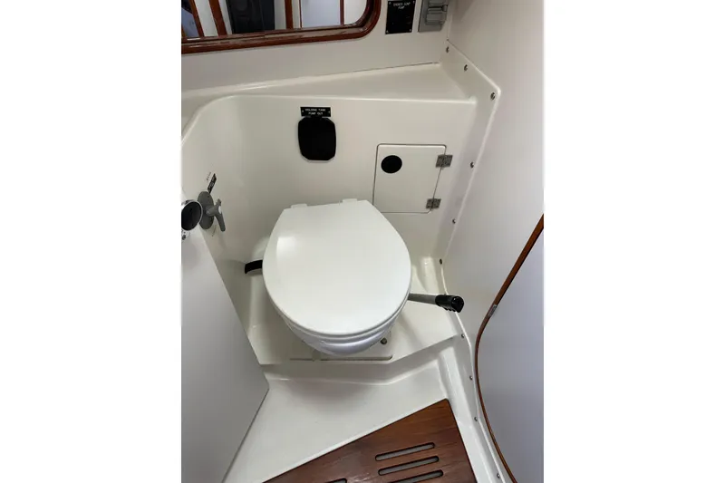 Slide: The Image of 1996 J Boats J/120 yacht bathroom with white marine toilet and wooden floor accents. - 68