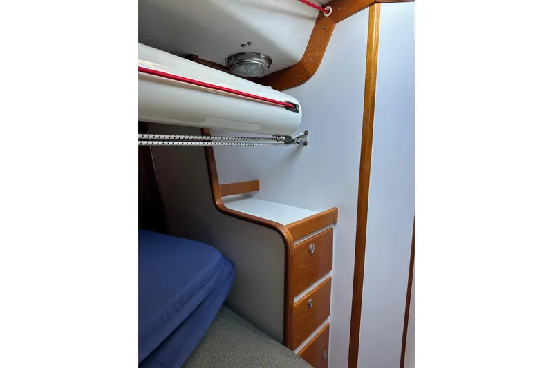 Slide: The Image of Interior of 1996 J Boats J/120 sailboat with wooden drawers and blue cushions. - 79