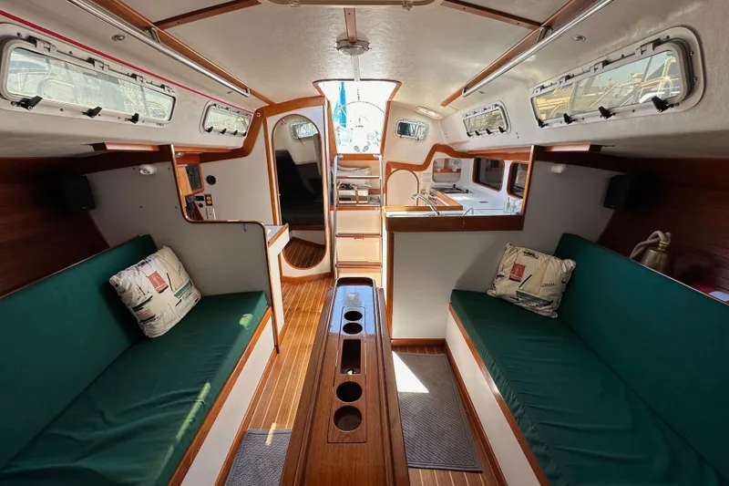 Slide: The Image of Interior of 1996 J Boats J/120 sailboat with green seating and wooden accents. - 84