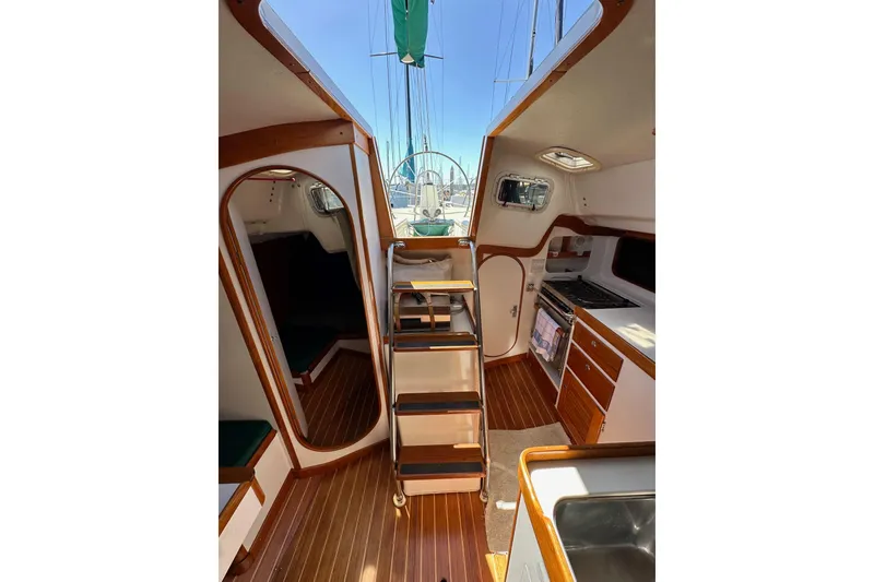 Slide: The Image of Interior of 1996 J Boats J/120 sailboat with wood accents and compact kitchen area. - 85