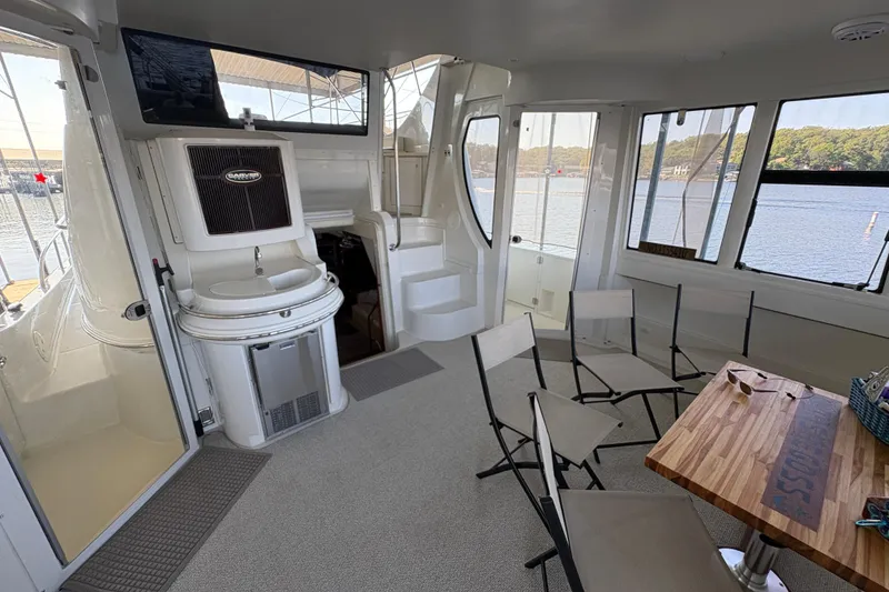 Slide: The Image of Interior of 2002 Carver 506 Motor Yacht with seating and table, overlooking water. - 15