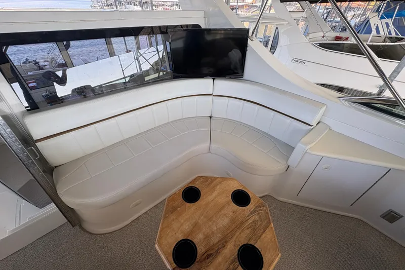 Slide: The Image of Luxurious interior of 2002 Carver 506 Motor Yacht with white seating and wooden table. - 32