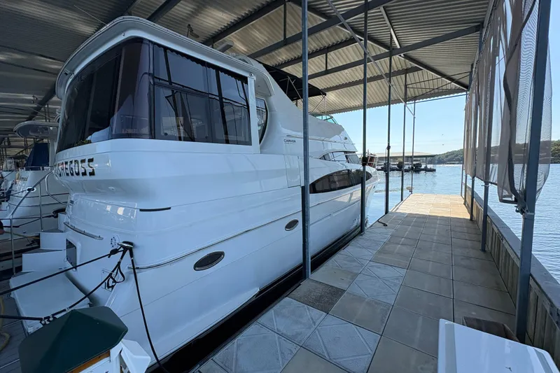 Slide: The Image of 2002 Carver 506 Motor Yacht docked in a covered marina with scenic water view. - 10