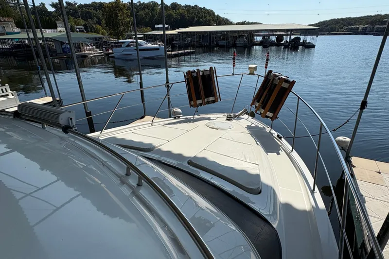 Slide: The Image of 2002 Carver 506 Motor Yacht docked at a serene marina, surrounded by calm waters. - 18